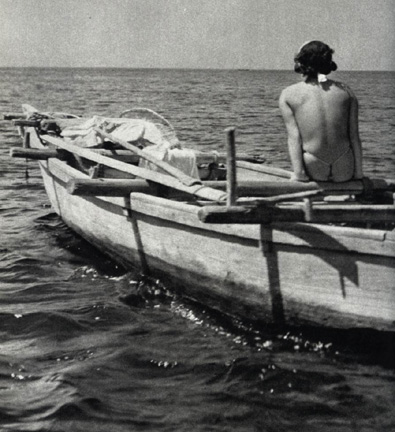 Semi-nude Asian woman on fishing boat out to sea.