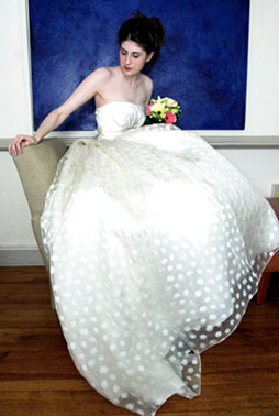 Beautiful, pale skinned brunette in bridal gown holding flowers