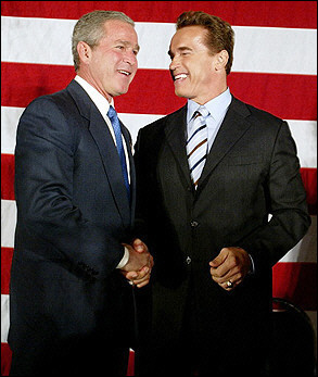 Arnold Schwarzenegger & President Bush shaking hands in front of American flag at a Republican convention