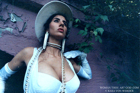 Photo of voluptuous woman with huge breasts in arm length white opera gloves and low cut white brazier outside at dusk