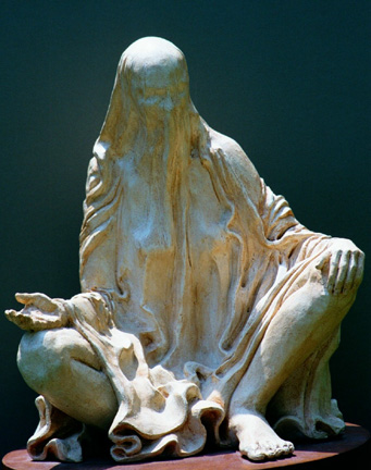 Statue of veiled woman seated in the louts pose with hand open in the giving and receiving of the divine shakti