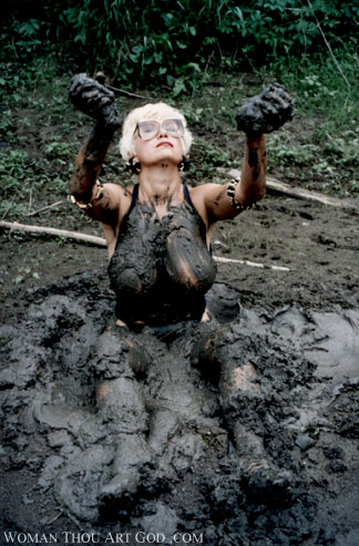 Sexy muscular woman exhaltating to the light while stuck in mud. Legs completely drowned in gooey mud.